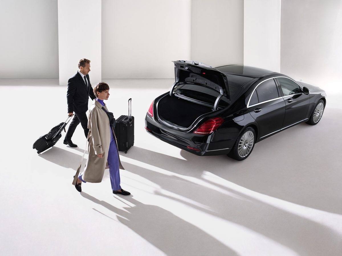 Chauffeur loading luggage for a door-to-door intercity transfer